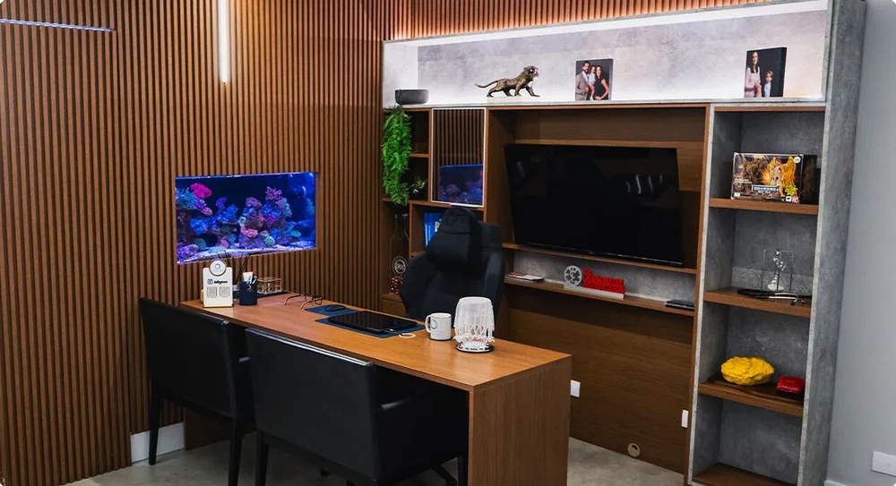 Consultório da Clínica O3, com mesa de atendimento, painel de madeira e aquário