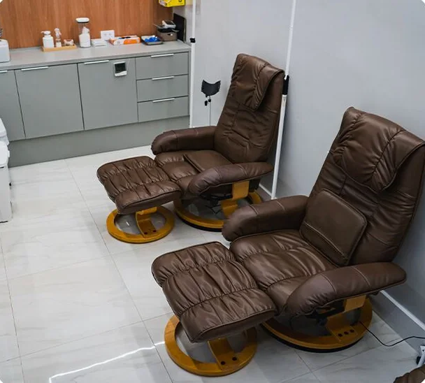 Sala com duas poltronas reclináveis de couro na Clínica O3